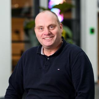 a man in a black shirt sitting in a chair